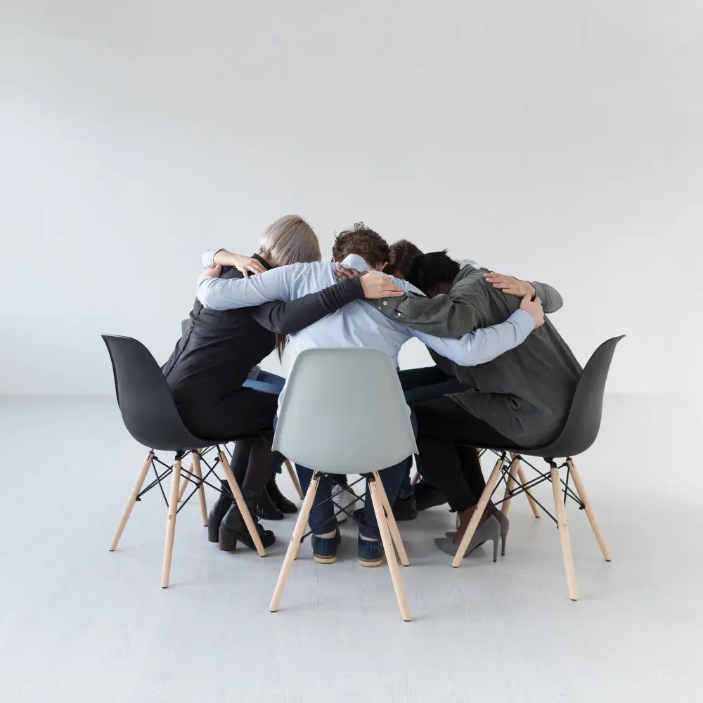 rehab-patients-standing-chairs-embracing What is Huffing Addiction and How Does it Develop?