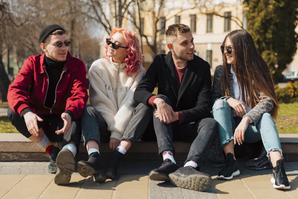 young-people-sitting-curb-talking-each-other Teen Drug Abuse Facts & Their Implications