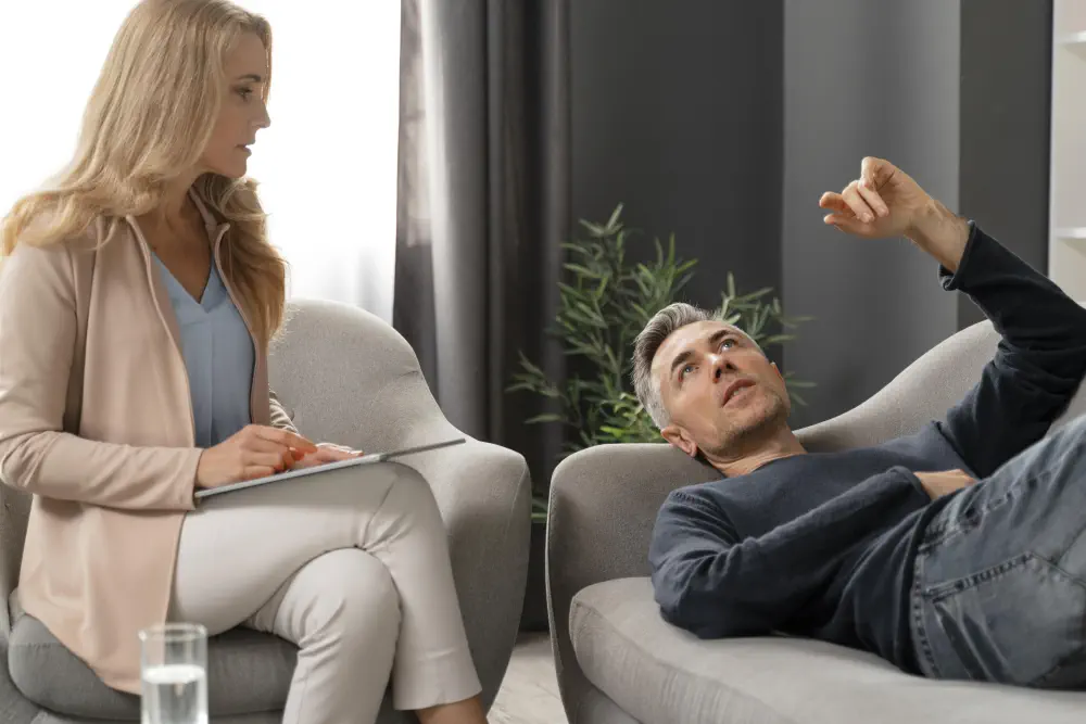 mid-shot-man-laying-couch-therapy-cabinet-near-counselor How Long Does Drug Rehabilitation Take? Length of Addiction Treatment