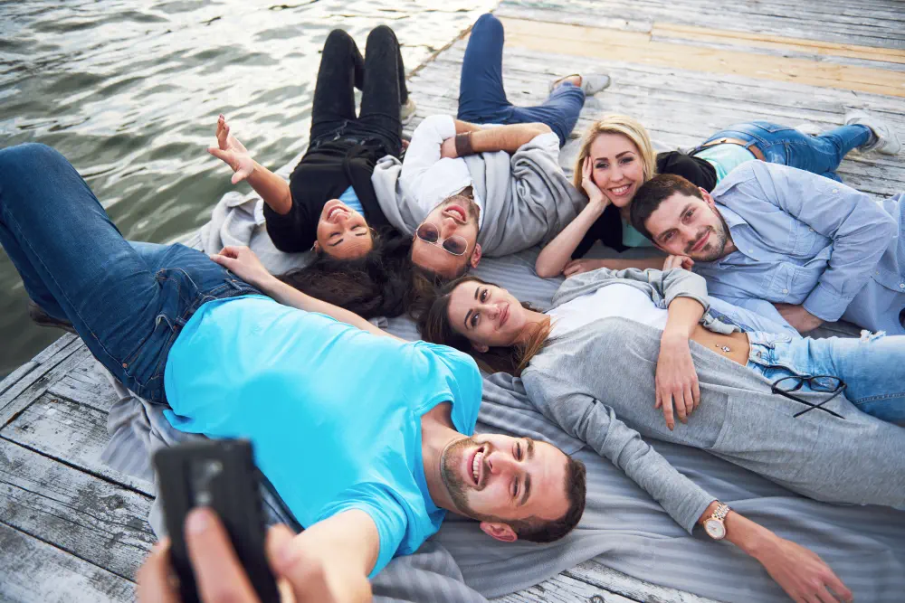 portrait-happy-young-friends-pier-lake-while-enjoying-day-doing-selfie What is the Treatment for Video Game Addiction?