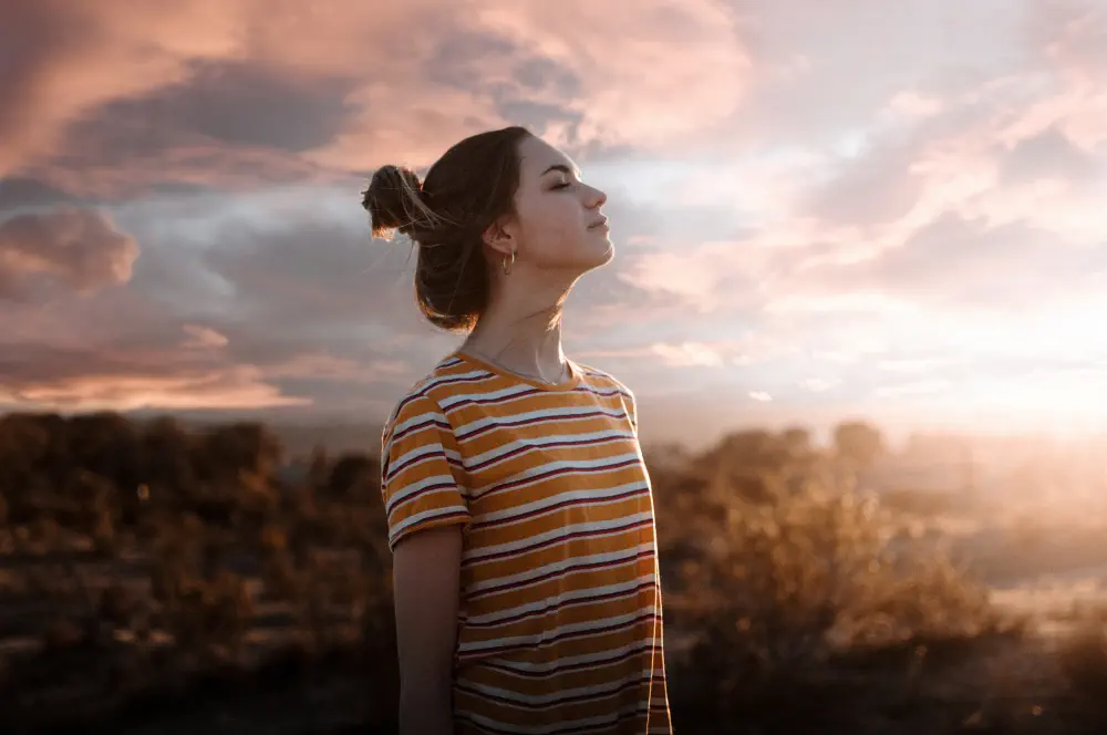 woman-with-eyes-closed-standing-against-sky-sunset How Long Does Drug Rehabilitation Take? Length of Addiction Treatment