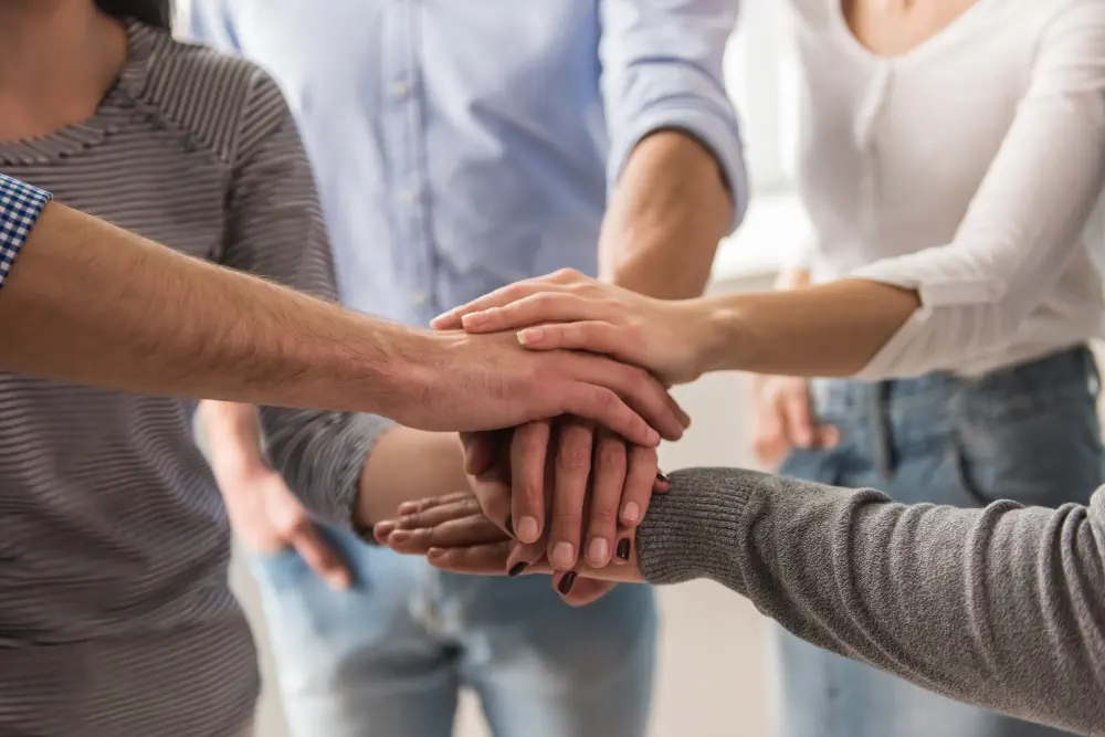 young-people-casual-clothes-putting-hands-together Why Does Somatic Therapy Work for Addiction?