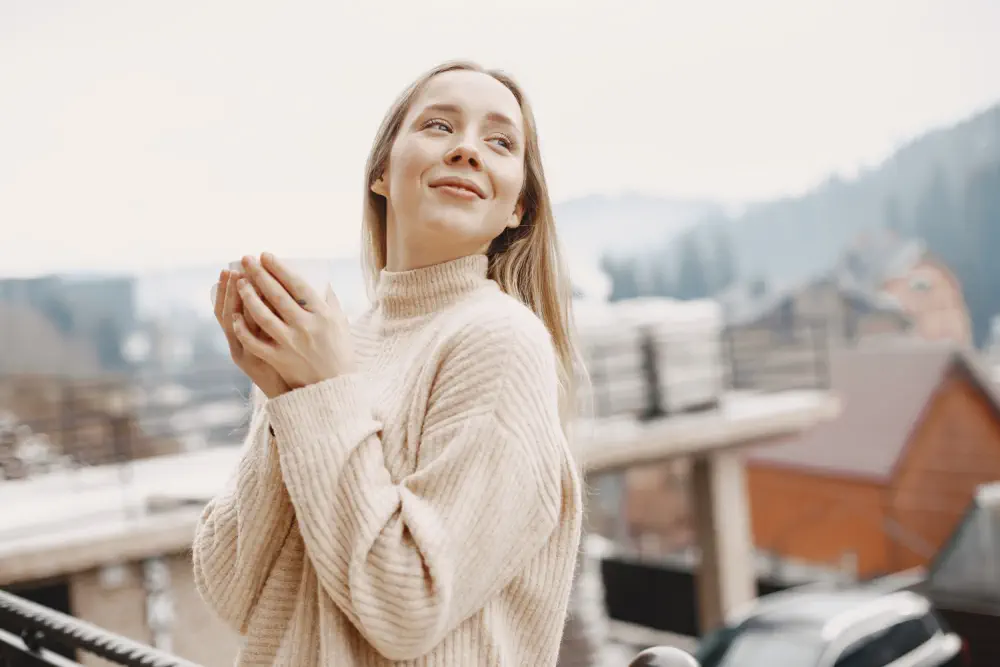 Woman holding cup on balcony.