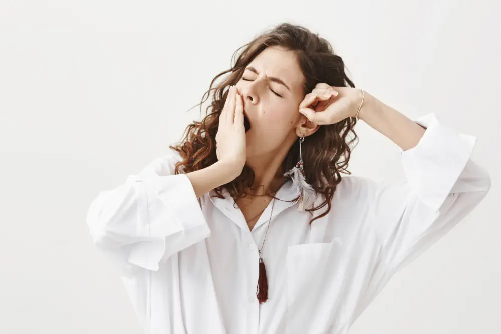  Woman yawning to represent natural sleep signals.